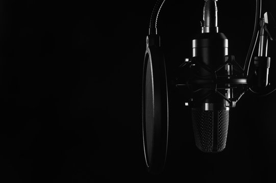 Studio condenser microphone isolated on black. Radio, vocals, podcasts. Copy space.
