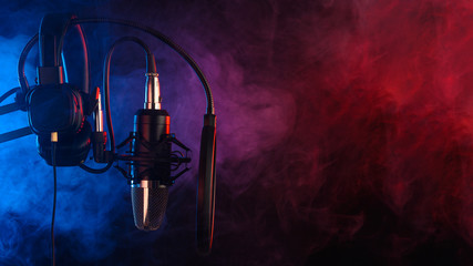 Close up studio condenser microphone on stand and anti-vibration mount. Live recording with colored...