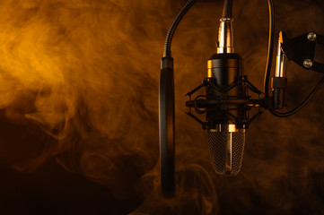Close up studio condenser microphone on stand and anti-vibration mount. Live recording with colored...