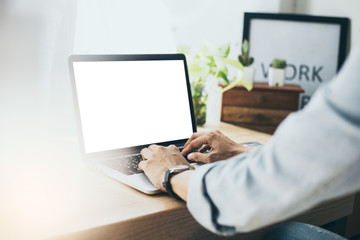 mockup image blank screen computer with white background for advertising text,hand man using laptop contact business search information on desk at home office.marketing and creative design
