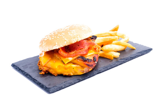 A picture of cheesy bbq grilled burger with fries insight on slate plate.