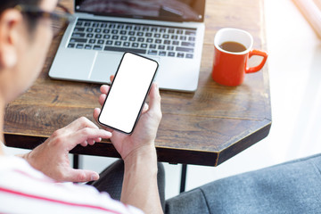 Mockup image blank white screen cell phone.man hand holding texting using mobile on desk at home office.background empty space for advertise text.people contact marketing business,technology