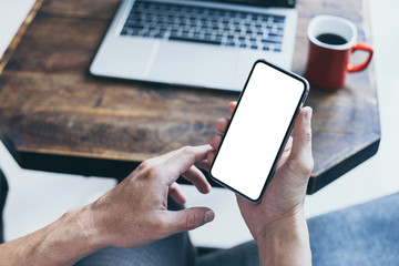 Mockup image blank white screen cell phone.man hand holding texting using mobile on desk at home office.background empty space for advertise text.people contact marketing business,technology