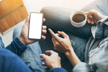 Mockup image blank white screen cell phone.man hand holding texting using mobile on desk at home office.background empty space for advertise text.people contact marketing business,technology