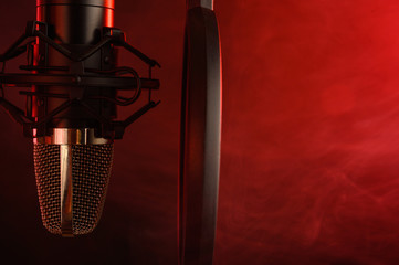 close-up. Studio condenser microphone Radio, vocals, podcasts red smoke. Copy space.