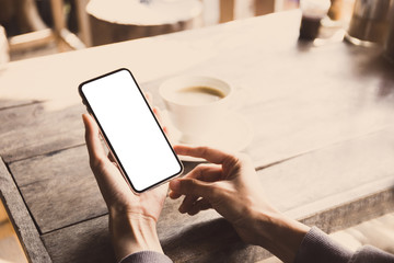 Mockup image blank white screen cell phone.man hand holding texting using mobile on desk at coffee shop.background empty space for advertise text.people contact marketing business,technology