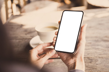Mockup image blank white screen cell phone.man hand holding texting using mobile on desk at coffee shop.background empty space for advertise text.people contact marketing business,technology