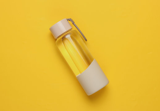 Bottle Of Water For Sports And Outdoor Activities On Yellow Background. Top View