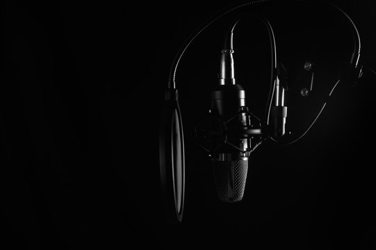 Studio condenser microphone isolated on black. Radio, vocals, podcasts. Copy space.