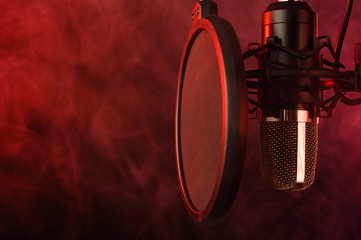 close-up. Studio condenser microphone Radio, vocals, podcasts red smoke. Copy space.