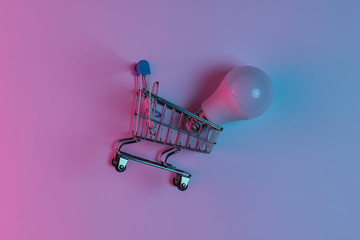 Shopping trolley with LED light bulbs. Neon pink blue night light