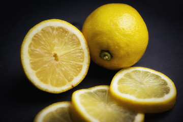 Primer plano de un conjunto de limones sobre una bandeja negra de piedra