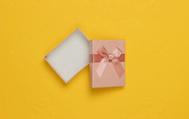 Open Gift box with bow on yellow background. Composition for christmas, birthday or wedding. Top view