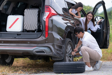 Fototapeta na wymiar Asian man and his family try to change new tire