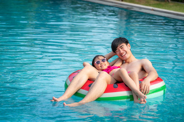 Fototapeta na wymiar Asian father play with her daughter in a swimming pool