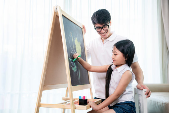 Asian teacher teach he student to draw a flower in a blackbord
