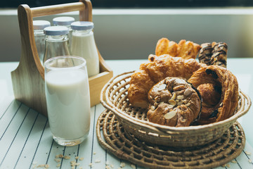 healthy eating and traditional bakery concept; fresh bread on the kitchen table with beverage at morning