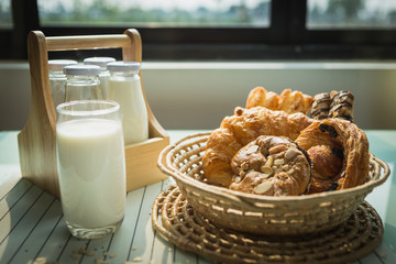 healthy eating and traditional bakery concept; fresh bread on the kitchen table with beverage at morning