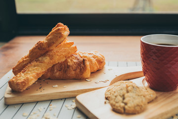 healthy eating and traditional bakery concept; fresh bread on the kitchen table with beverage at morning