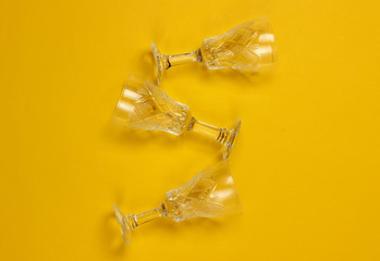 Retro style faceted crystal wine glasses on a yellow background.