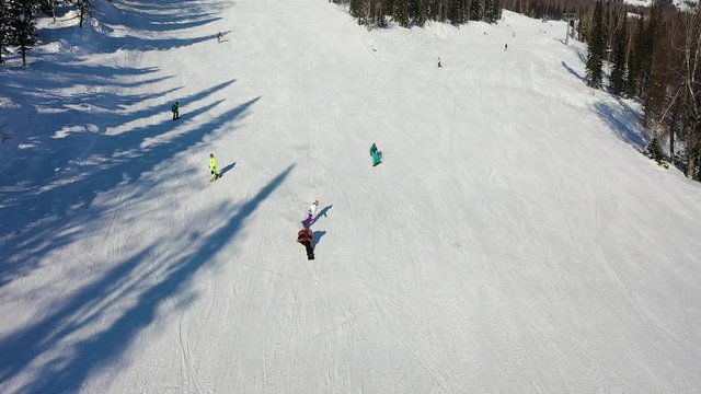 Ski slope. Skiers and snowboarders roll down the track. Aerial photography of a skier descending a wide ski slope