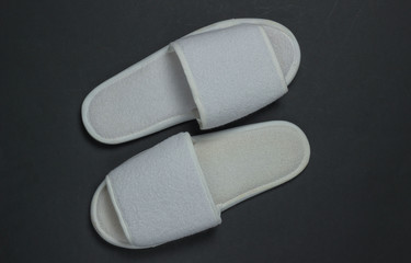 White sleeping slippers on a black background. Top view
