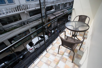 The two deck chairs and a small table in the balcony with a view