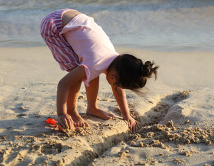 A girl plays in the sand