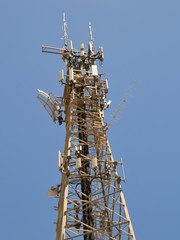 Telecommunications tower for television radio and mobile cellphone repeating against a blue sky