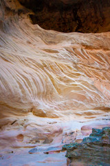 Stone waves on the floor of a cave. Contrast of foreground and background. Sandstone Caves, Pilliga National Park, NSW, Australia. Vertical orientation.