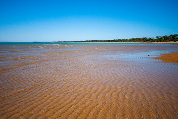 The coastal strip (coastline, beach) at low tide. A wavy relief runs along it. Hervey Bay, Queensland, Australia.