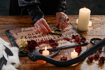 Mystic ritual with Devil's board and candles. The girl calls spirits.The mystical atmosphere of...