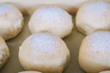 Homemade sweet buns with powdered sugar. Sweet breakfast.Close up view of baker is working.Tasty sweet buns with sweetened condensed milk, Thai tea custard on plate and icing sugar