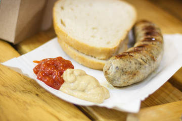 Portion of grilled sausage with bread and spices. Traditional polish food