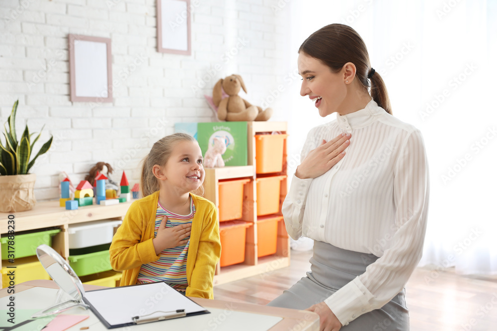 Poster Speech therapist working with little girl in office