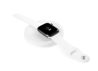 Smartwatch charging with wireless pad isolated on white