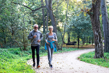 Obraz premium Mature couple man and woman jogging in the park