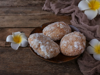A Malay traditional dessert called Gagatas or Getas on plate with flower and cloth decoration over wooden background 