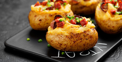 Hot baked potato topped with bacon, green onions and sun dried tomatoes.