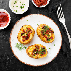Hot baked potato topped with bacon, green onions and sun dried tomatoes. top view