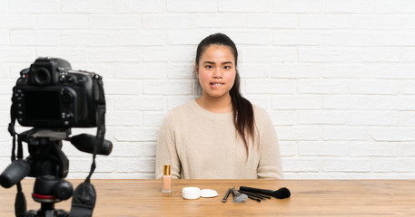 Young blogger Asian girl recording a video tutorial having doubts and with confuse face expression