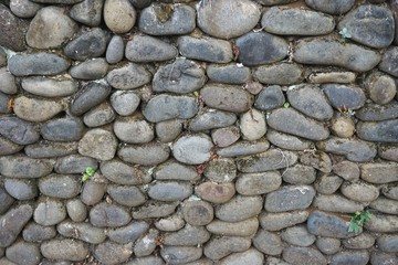 Horizontal stone wall built with smooth round river rocks set in mortar