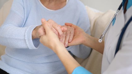 Hand Of Doctor Reassuring Her Senior Female Patient