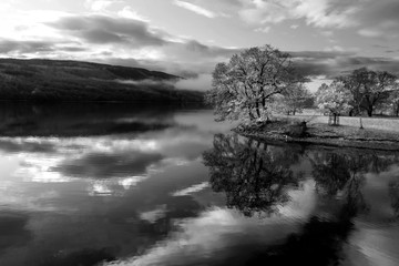 Breathtaking vibrant aerial drone landscape images over Coniston Water at sunrise on beautiful Autumn Fall morning