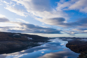 Breathtaking vibrant aerial drone landscape images over Coniston Water at sunrise on beautiful Autumn Fall morning