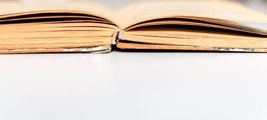 Close up shot of an open old science book containing equations and graphs from different fields: math, physics, chemistry. The pages have the marks of the past as they got orange.