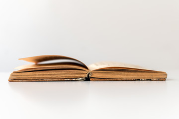 Close up shot of an open old science book containing equations and graphs from different fields: math, physics, chemistry. The pages have the marks of the past as they got orange.