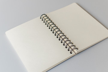 Close up shot of an open blank sketchbook placed on a light gray table.