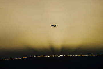 Jet plane landing in sunrise time in front of dramatic sky.
