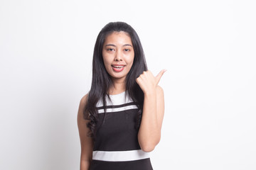 Obraz premium Young Asian woman smile and point to copy space with her thumb.